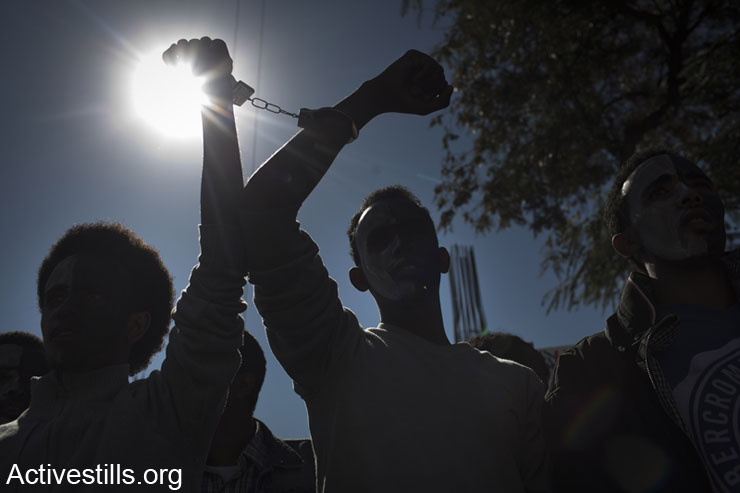 African asylum seekers shout slogans during a protest in front of the UN refugee agency (UNHCR), Tel Aviv, February 13, 2014. The demonstrators protested against the Holot detention center for African immigrants, and called on the Israeli government to recognize their refugee rights. (photo: Oren Ziv/Activestills.org)