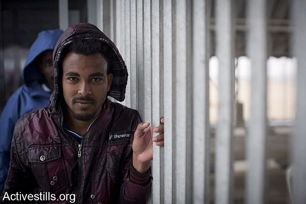 An African asylum seeker jailed in Holot detention center waits to re-enter the facility after meeting activists and friends who came for a solidarity visit, Negev, February 15, 2014. (photo: Oren Ziv/Activestills.org)