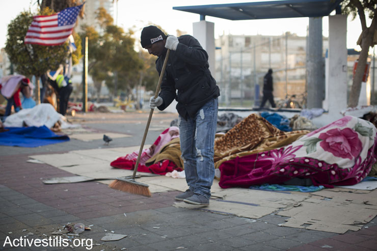 An Eritrean Asylum seeker cleans, after spending the night in Levnisky park, South Tel Aviv, on their eighth day of an on going protest, on the early hours of February 9, 2014. (photo: Oren Ziv/Activestills.org)