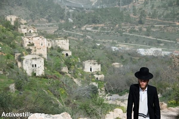 An ultra-orthodox Jewish man walks in the depopulated Palestinian village of Lifta, located on the edge of West Jerusalem, Israel, March 4, 2014. During the Nakba, the residents of Lifta fled attacks by Zionist militias beginning in December 1947, resulting in the complete evacuation of the village by February 1948. (Photo by Ryan Rodrick Beiler/Activestills.org)