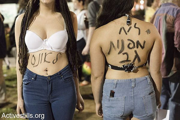 Women at the protest against 'rape culture' in Tel Aviv. Written on the women's bodies, from left to right, is "for raping" and "We won't turn our backs," March 29, 2014, Tel Aviv. (Photo by Keren Manor/Activestills.org)