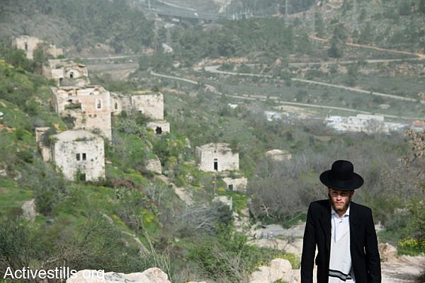 An ultra-orthodox Jewish man walks in the depopulated Palestinian village of Lifta, located on the edge of West Jerusalem, Israel, March 4, 2014. During the Nakba, the residents of Lifta fled attacks by Zionist militias beginning in December 1947, resulting in the complete evacuation of the village by February 1948. (photo: Ryan Rodrick Beiler/Activestills.org)