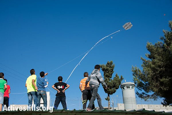 Children from Aida Refugee Camp fly kites over the Israeli separation wall during a Nakba commemoration event, May 14, 2014.