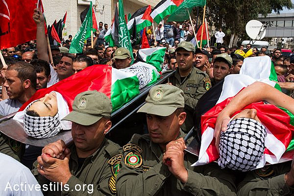 Members of the Palestinian national security forces carry the bodies of Nadim Nawara and Muhammad Salameh during their funeral procession in the West Bank city of Ramallah on May 16, 2014. Both teens were shot dead by Israeli forces during clashes the previous day outside the Israeli-run Ofer prison following a protest commemorating the Nakba. (Activestills.org)