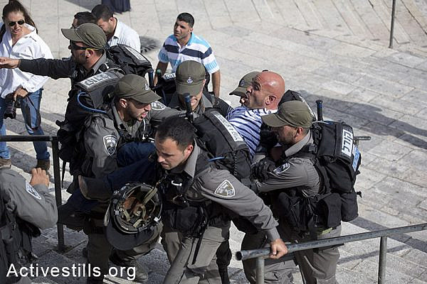 Israeli border policemen detain a Palestinian journalist before Israeli settlers and Ultra-nationalists take part in the 'flag march' through Damascus Gate in east Jerusalem, on May 28, 2014, celebrating the anniversary of its capture in the 1967 Six-Day War.
Police prevented from Palestinians to gather and  protest against the march, and attacked journalists that were covering  the event. (Oren Ziv/Activestillsorg)