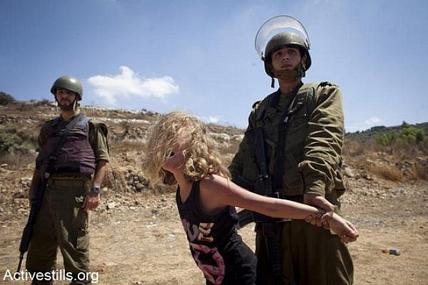 Illustrative photo of a young Palestinian girl being detained by Israeli soldiers. (Photo by Activestills.org)