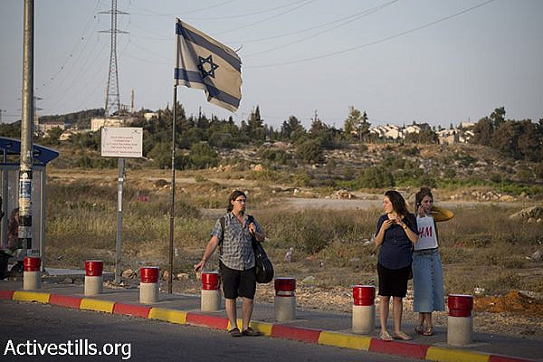 Israeli setters hitchhike at the Gush Etzion junction, next to the Palestinian town of Bethlehem, June 16, 2014. (Oren Ziv/Activestills.org)