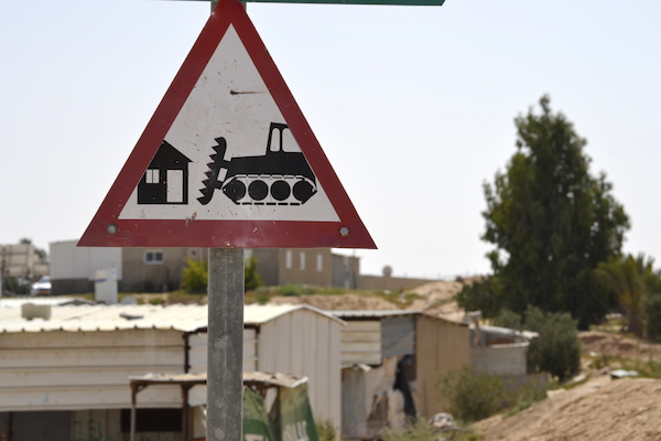 A sign at the entrance of the unrecognized Bedouin village of Alsira warns of home demolitions. Villagers had the sign made. June 19, 2014. (Photo by Michael Omer-Man)