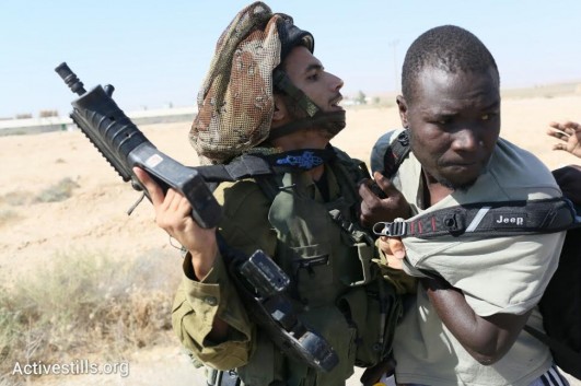 An Israeli soldier confronts an African asylum seeker during the march to the border with the Sinai Peninsula. (photo: Oren Ziv/Activestills.org)