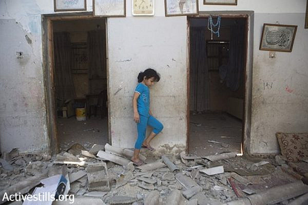 A child of Diab Bakr is seen amidst the rubble of his home which was destroyed last night by Israeli missiles, in As-Shati refugee camp, Gaza city, July 22, 2014. Another home from the extended Bakr family was also destroyed and another one damaged. Hassan Khader Bakr, was killed during the attack in the street. Their cousins, Bakr family who live in the same area, lost four children, Ahed (10), Zacharia (10), Mohamed (9) after they were targeted by two Israeli missiles while playing at the beach on 16 July, 2014. (Anne Paq/Activestills.org)