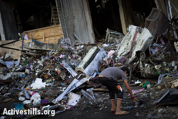 A child inspects the ruins of a house destroyed by an Israeli air strike in the Al Sheikh Radwan neighborhood of Gaza City, July 11, 2014.