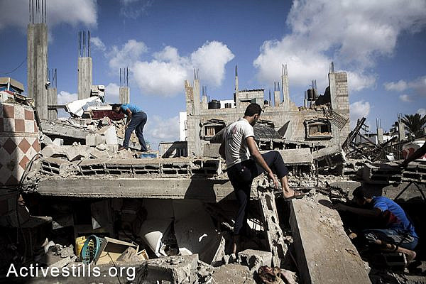 Palestinians look for injured or dead bodies under the rubble of the home of Abu Teir family which was bombed duri,h an Israeli attack, in Abasan village, East of Khan Yunis, July 27, 2014. During the ceasefire on 26 July, many Palestinians went back to Abasan to inspect the damages together with medics who attempted to rescue injured or collect bodies.  Israeli attacks have killed more than 1,000 Palestinians and injured around 5,000 in the current offensive. (Anne Paq/Activestills.org)