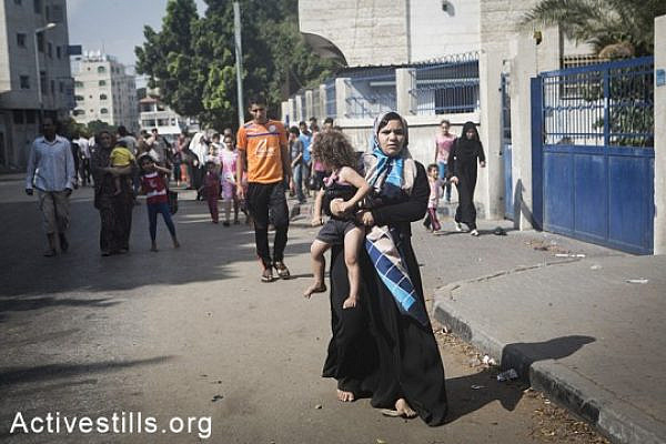 Gazans flee the Shejaiya area after Israeli tanks invaded the area, bombarding it heavily, causing over 60 casualties and hundreds wounded, July 20, 2014.  (Basel Yazouri/Activestills.org)
