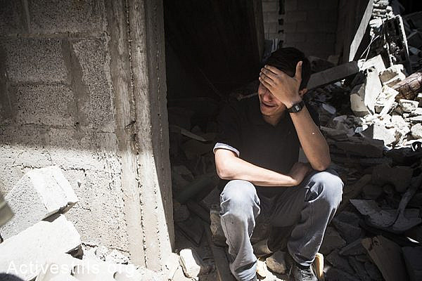 A Palestinian crying near rubbles of his home after the latest round of Israeli attacks against Al Shaja'ia, Gaza City, July 20, 2014.  (Anne Paq/Activestills.org)