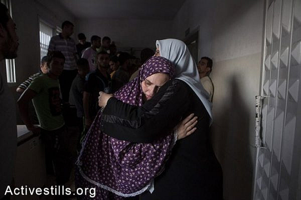 Mother (left) of Jihad Issam Shuhaibar (8), and Wasim Issam Shuhaibar (7), two of the children killed in an Israeli airstrike on in the Sabra neighborhood of Gaza City, is comforted by a relative in al-Shifa hospital, July 17, 2014. The third victim of the airstrike that hit children while they were playing on the roof of their house, was their cousin 10-year-old Afnan Tariq Shuhaibar. The airstrikes came immediately after a temporary five-hour humanitarian ceasefire between Hamas and Israel ended. As of July 17th, 237 Palestinians have been killed since the beginning of the Israeli military operation against the Gaza Strip, including 48 children, and more than 1,700 have been injured. (Anne Paq/Activestills.org)