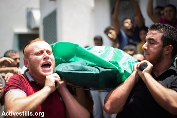 Members of the al-Batsh family are taken from Al Shifa Hosptial for their funeral, Gaza City, July 13, 2014. An Israeli airstrike on the family home of Tayseer Al-Batsh, Gaza's police chief, killed 18 people the previous day. (Photo: Basel Yazouri/Activestills)