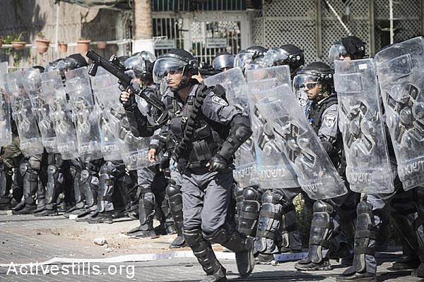 Israeli riot policemen shoot tear gas at Palestinians in Shuafat during the funeral of Muhammad Abu Khdeir. (photo: Oren Ziv/Activestills.org)