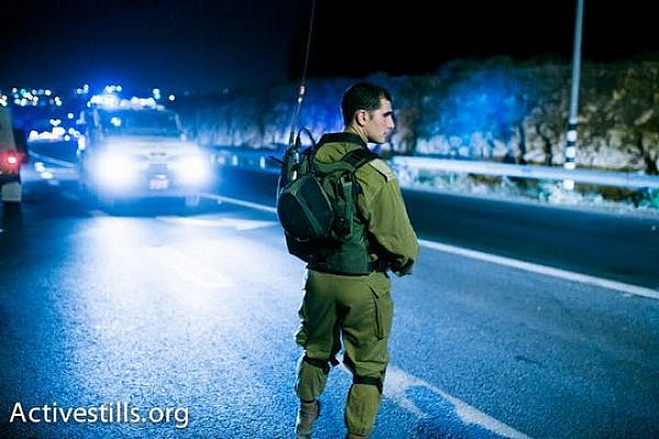 Israeli army officer next to the site where the bodies of three missing teens were located, June 30 2014 (photo: Activestills)