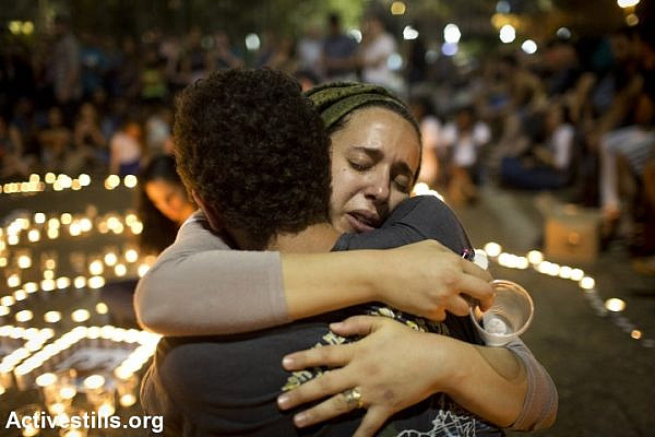 Israeli mourners console each other during a memorial for the three murdered teens in Rabin Square, Tel Aviv. (photo: Activestills)