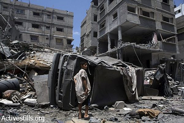 Homes in Beit Lahiya lie in ruins after the Israeli bombing of the Rozanah family home, Gaza Strip, August 2, 2014. The homes of five families were destroyed, leaving 60 people homeless. (Anne Paq/Activestills.org)