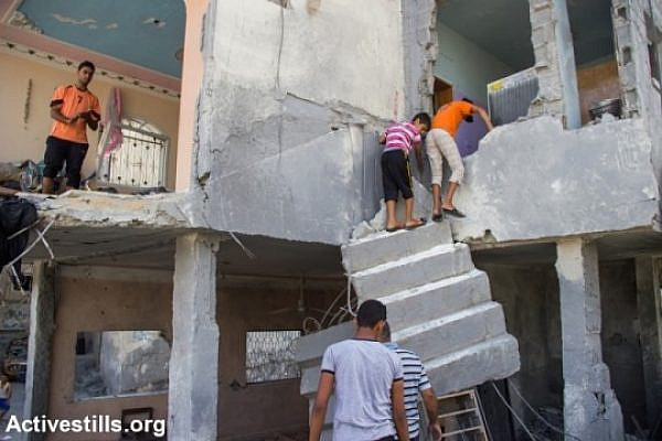 Palestinians retrieve belongings from their destroyed home in Beit Hanoun, northern Gaza Strip, August 12, 2014. According to OCHA, 16,800 homes in the Gaza Strip have been destroyed or severely damaged, leaving 370,000 displaced. (photo: Activestills)