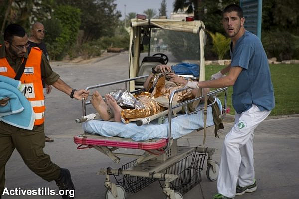 Medics and soldiers bring an Israeli wounded by rocket fire to Soroka Hospital, Be'er Sheva. (photo: Oren Ziv/Activestills.org)