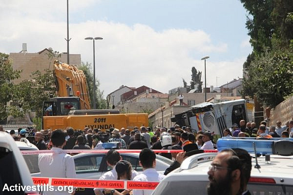 Police cordon off area after a Palestinian man rams digger into a public bus in Jerusalem. (photo: Activestills.org)