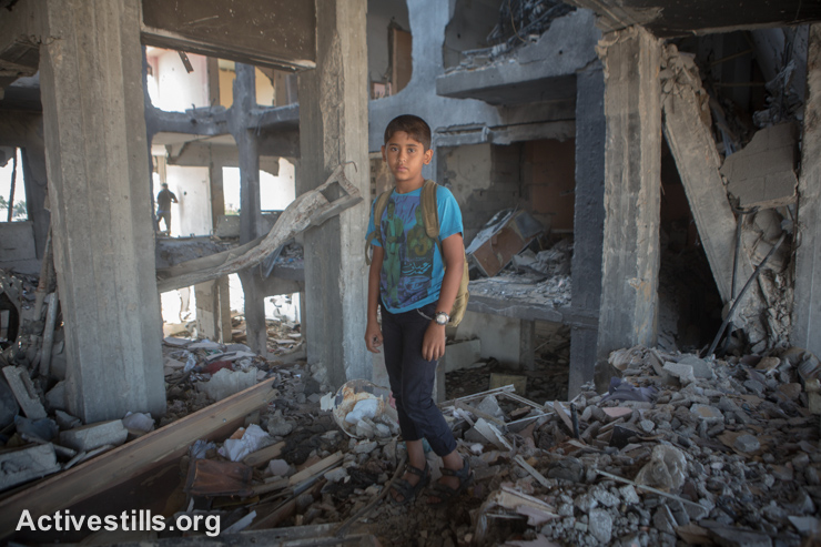 Mohammed, age 11, stands in the remains of his home in the Al Nada Towers of Beit Hanoun in the northern Gaza Strip after they were destroyed by Israeli strikes. The towers had 90 flats, the homes of many families.