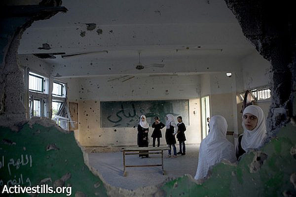 Palestinian school students stand in a destroyed classroom in the damaged Sobhi Abu Karsh Basic school in a destroyed quarter of the Shujayea neighborood, Gaza city, September 15, 2014. The school year has started with a three-week delay, due to the latest Israeli offensive during which 29 schools have been totally destroyed, and around 190 damaged. The first weeks are dedicated to recreational activities to help children to overcome the trauma due the the seven-week Israeli military offensive. 2,131 Palestinians were killed, including 501 children, and an estimated 18,000 housing units have been either destroyed or severely damaged, leaving more than 108,000 people homeless.