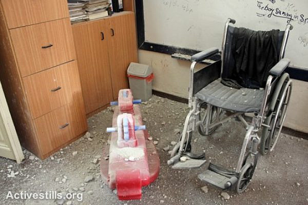 Toys and a wheelchair lie covered in dust and rubble after a center for children with disabilities was raided
by Israeli forces in the West Bank city of Nablus, September 3, 2014. (Activestills.org)