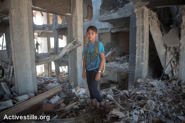 Mohammed, age 11, stands in the remains of his home in the Al Nada Towers of Beit Hanoun in the northern Gaza Strip after they were destroyed by Israeli strikes. The towers had 90 apartments, home to many families. (photo: Activestills.org)