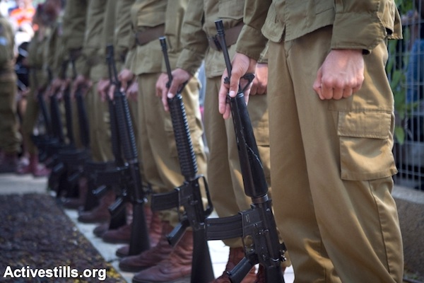 Soldiers in an IDF honor guard hold their weapons during the funeral for a soldier killed in Gaza, July 20, 2014, Holon, Israel. (Photo by Oren Ziv/Activestills.org)