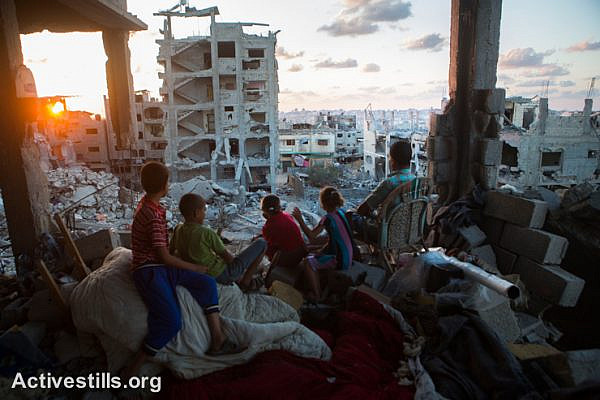 A Palestinian family sits in their destroyed home in the At-Tuffah district of Gaza City, which was heavily attacked during last Israeli offensive, September 21, 2014.