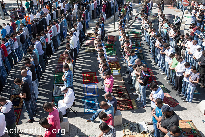 Palestinians perform Friday Prayers at the neighberhood of Ras Al-Amud  due to Israeli Government's entrance restriction to the al-Aqsa Mosque for the Palestinians under the age of 40 in Jerusalem, October 24, 2014. (Activestills.org)