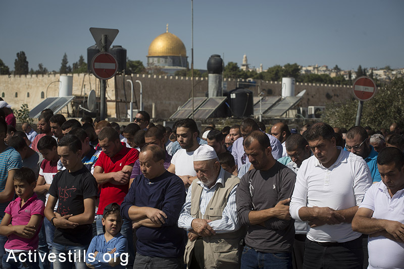 Palestinians perform Friday Prayer at the neighbourhood of Ras Al-Amud in East Jerusalem due to Israeli Government's entrance restriction to the al-Aqsa Mosque for the Palestinians under the age of 40, October 24, 2014. (Activestills.org)