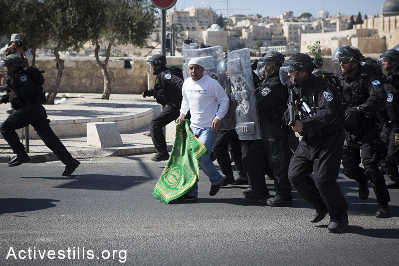 Israeli policemen push a Palestinian man at the end of Friday Prayer, at the neighbourhood of Ras Al-Amud in East Jerusalem, October 24, 2014. The Israeli Government restricted the entrance to the al-Aqsa Mosque for the Palestinians under the age of 40. (Activestills.org)