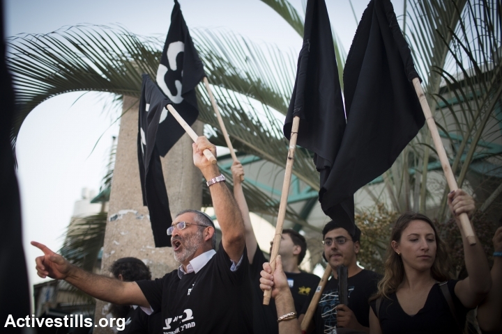 Former MK Michael Ben-Ari speaks during a protest against the Israeli High Court decision to cancel the "infiltrator law" and to close the Holot detention center, South Tel Aviv, October 5, 2014. (Activestills)