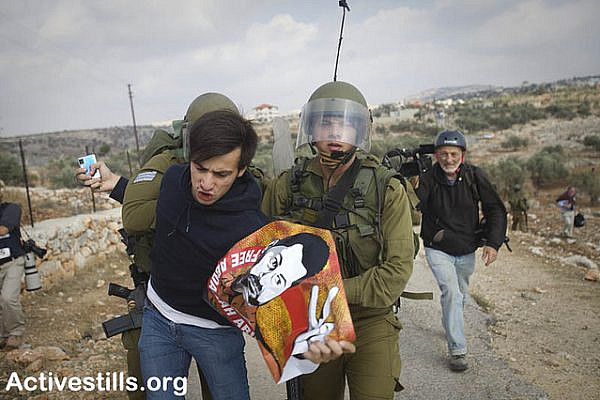Israeli soldiers arrest an Israeli protester during a demonstration against the separation wall in the West Bank village of Bil'in. (photo: Oren Ziv/Activestills.org)