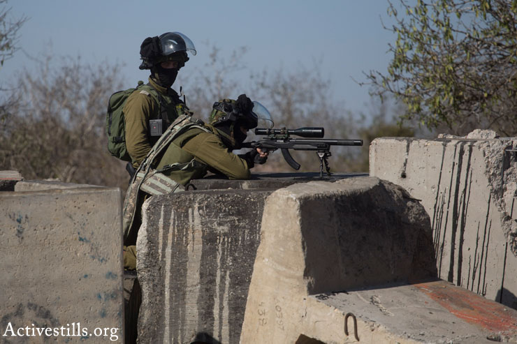 An Israeli sniper aims his weapon at Palestinian youths during clashes with the Israeli army following the funeral of 14-year-old Palestinian-American Orwah Hammad in the West Bank village of Silwad, October 26, 2014. (Photo by Oren Ziv/Activestills.org)