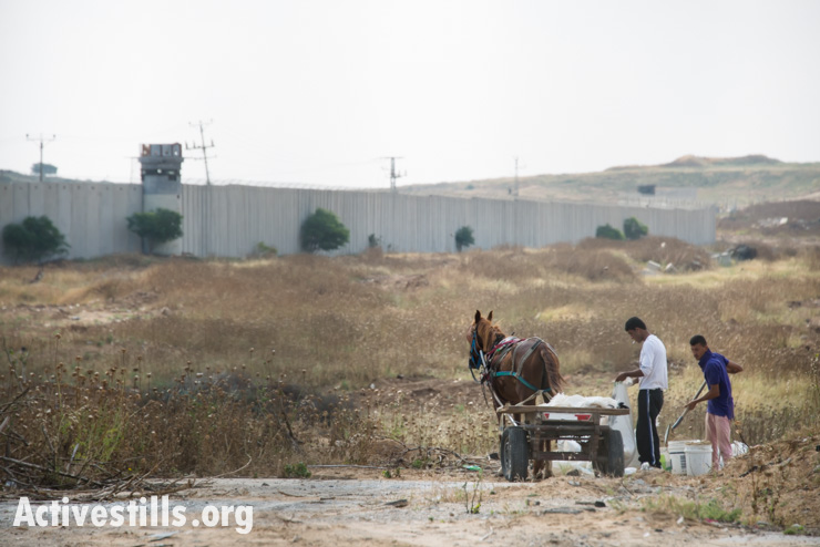 Palestinian workers salvage building materials near Erez Crossing at Gaza’s northern border, Beit Hanoun, May 11, 2014. Human rights organizations have documented dozens of cases of Israeli army gunfire at persons who posed no threat and were well outside the 300-meter so-called “no-go zone” imposed by the Israeli military inside Gaza’s borders. In many cases, no warning was given before soldiers opened fire. (photo: Ryan Rodrick Beiler/Activestills.org)
