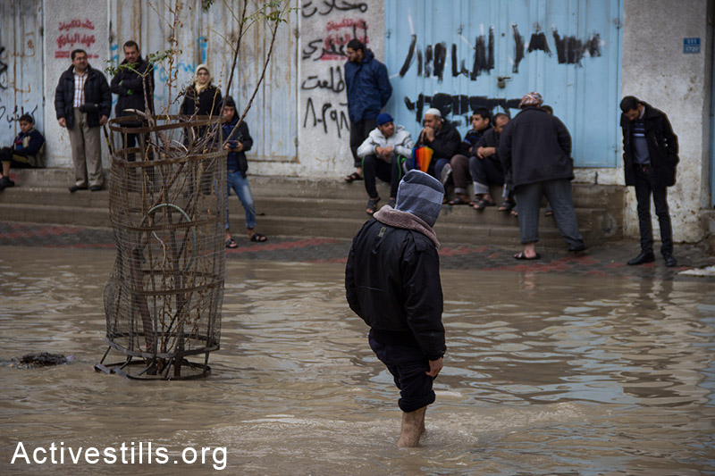Residents of Al-Nafaq in high waters flooding the neighborhood, Gaza City, November 27, 2014. Basel Yazouri/Activestills.org