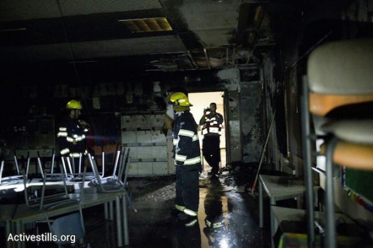 Firefighters in a classroom that was set on fire in the bilingual Hand In Hand school in Jerusalem, November 29, 2014. (Photo by Tali Mayer/Activestills.org)