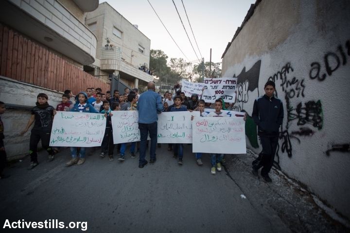 Palestinian protesters and Israeli activists demonstrate against new concrete blockades put in place by Israeli police restricting access to the East Jerusalem neighbourhood of Issawiya, November 12, 2014. Israeli police had blocked off three of the four entrances leading to Issawiya due to recent clashes between Palestinian youths and Israeli police. (Faiz Abu Rmeleh/Activestills.org)