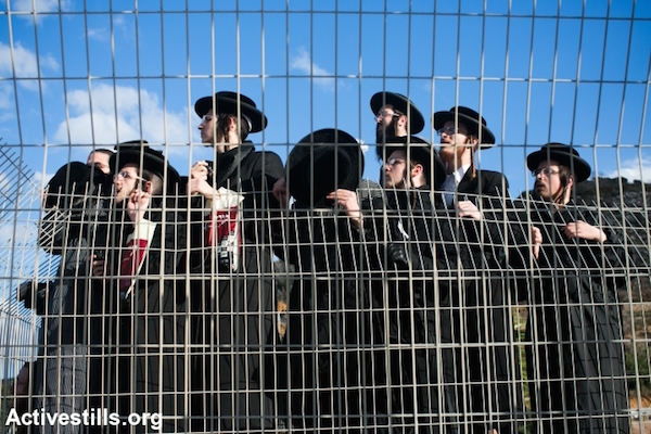 Ultra-Orthodox Jews gather during a protest against their military conscription outside a military prison on December 9, 2013 in Atlit, Israel. Hundreds of Ultra-Orthodox Jews protested outside the prison following the arrest of a young man who refused to serve in the Israeli the army, September 12, 2013. (Photo by Yotam Ronen/Activestills.org)