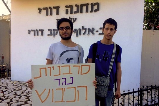 Udi Segal (right) arrives with supporters to an IDF induction base. The sign says, 'Refuseniks Against the Occupation' (Photo courtesy of 'Refuseniks Against the Occupation'