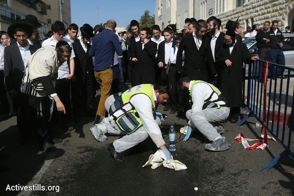 ZAKA volunteers collect blood, according to Jewish ritual, at the scene of a Jerusalem synagogue where two Palestinians killed four worshippers and seriously wounded eight others, November 18, 2014. (Photo by Oren Ziv/Activestills.org)
