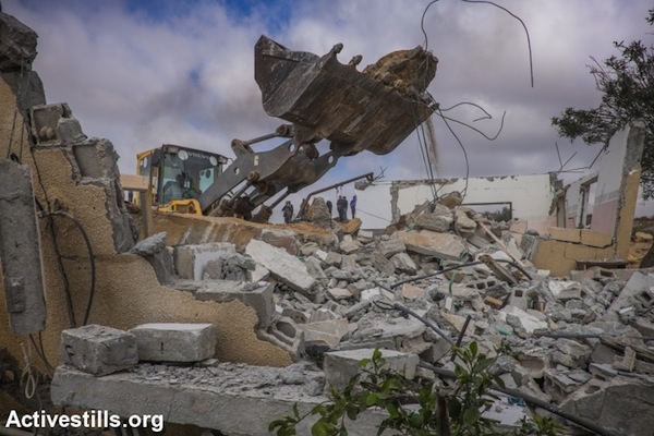 A Bedouin family demolishes its own home in the unrecognized village of Sawa, Negev Desert, December 23, 2014. (photo: Yotam Ronen/Activestills.org)