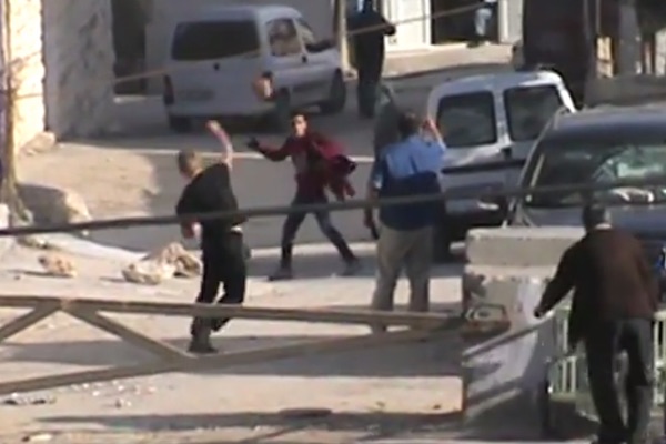 Screenshot of an Israeli settler and Palestinian youth throwing stones at each other. (B'Tselem)