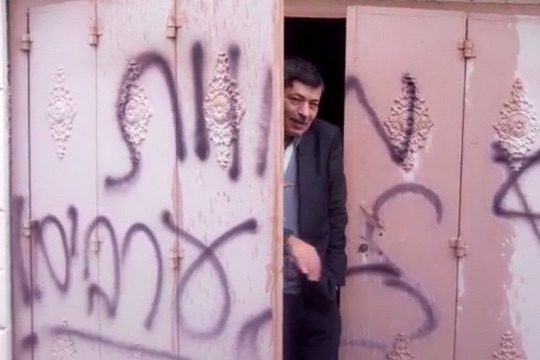 Ziad Abu Ein exits a Palestinian home that settlers vandalized with graffiti reading "Death to Arabs" in late November. (Photo by Rabbis for Human Rights)