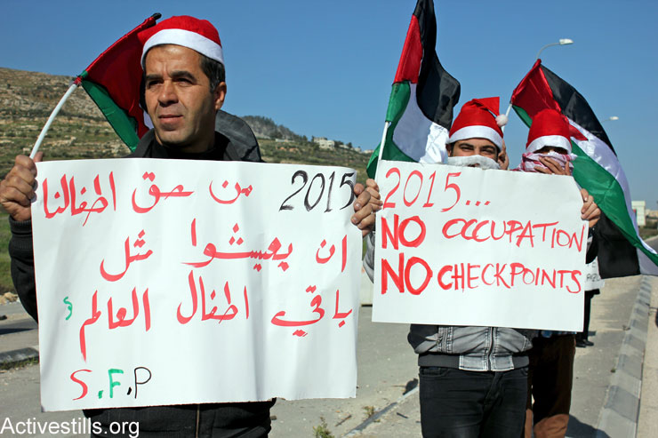 Palestinian activists protest against the Israeli occupation at the Huwwara military checkpoint, south of Nablus, January 1, 2015. (Photo by Ahmad Al-Bazz/Activestills.org)
